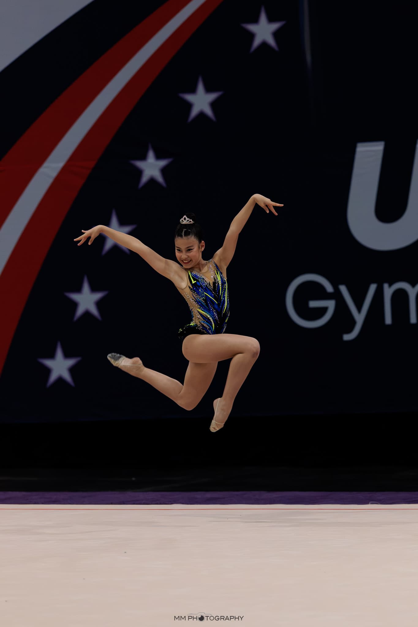 A gymnast in a joyful leap at a national competition