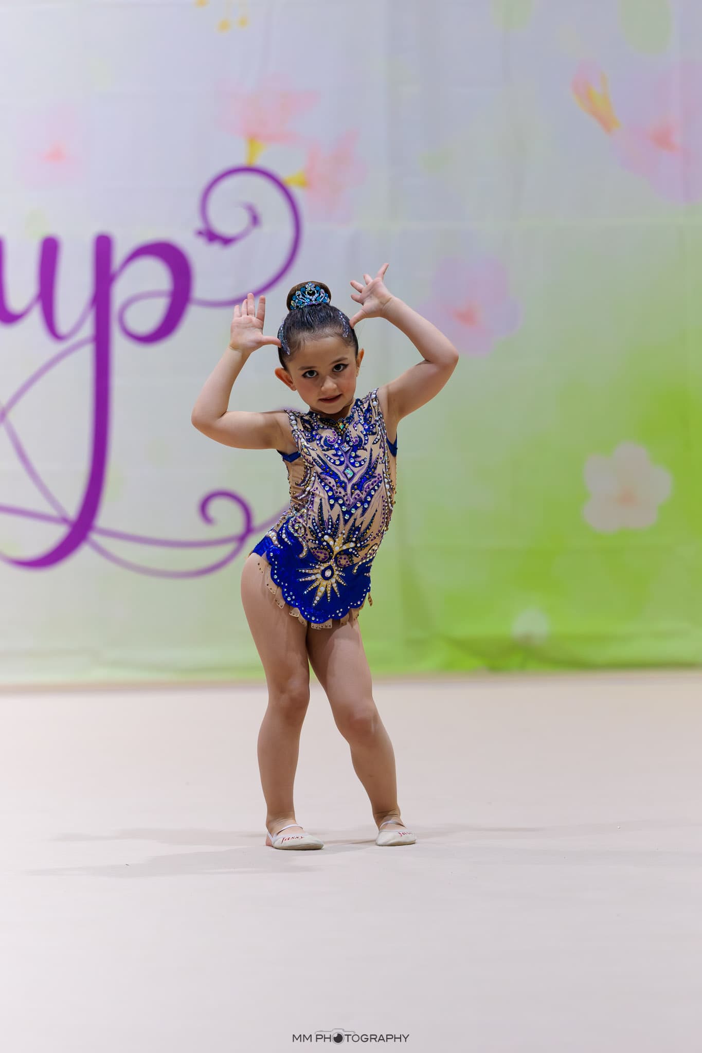A young gymnast posing playfully during a floor routine