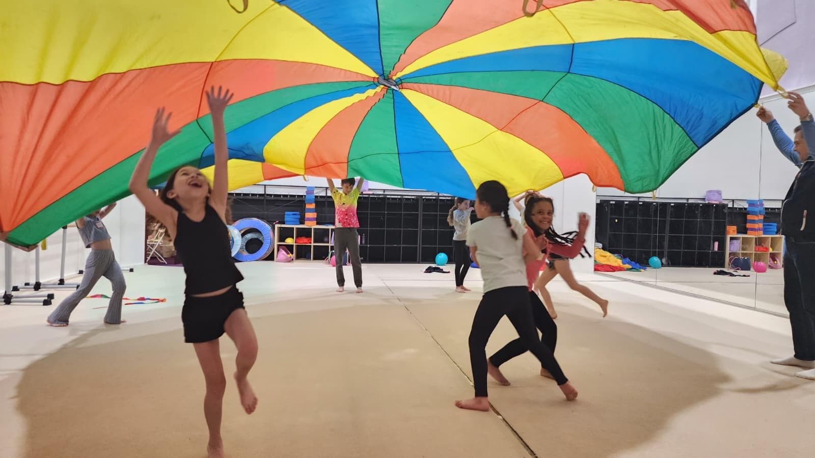 Children playing a parachute game at a Boston Rhythmic birthday party